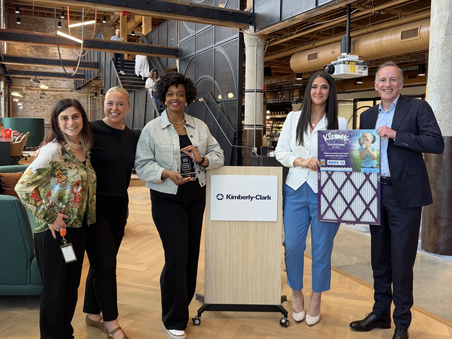 Jessie Cooper, Leah McInerney, Sharnell Weathersby holding her Asthma & Allergy Friendly® award, [name] holding a Kleenex® Elite Allergen MERV 13 Air Filter, and Dr. John Ryan at Kimberly-Clark's Chicago offices