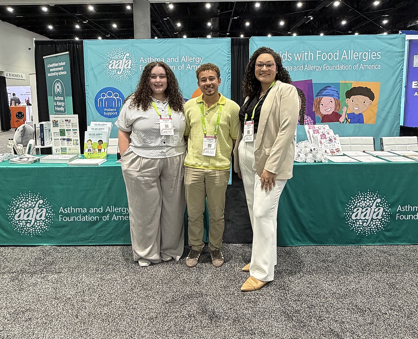Three members of the Asthma and Allergy Foundation of America team standing in front of the AAFA booth at the AAP 2026 National Conference & Exhibition in San Diego